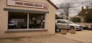 Devanture de l'agence des pompes funèbres Giraudet avec corbillard.