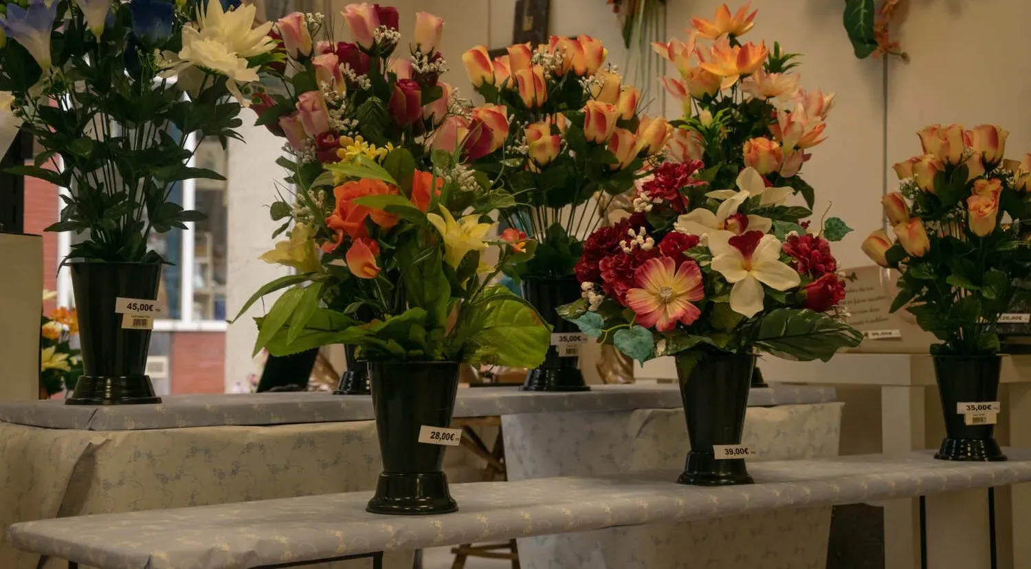 Compositions florales artificielles colorées en pots noirs avec prix en magasin.